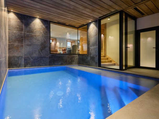 Piscine intérieure chalet avec bois et pierre