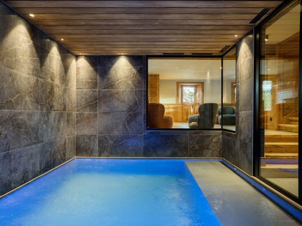 Piscine intérieure chalet avec bois et pierre