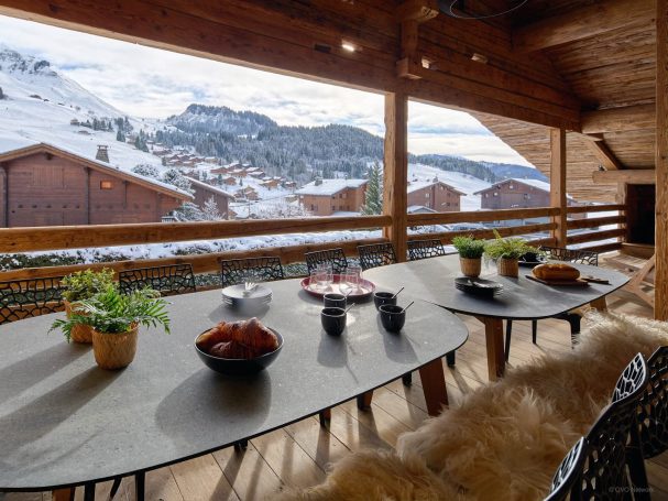 Balcon avec vue sur charpente traditionnelle et station de ski