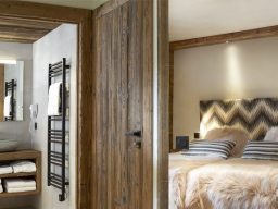 Salle de bain et chambre rénovées dans un chalet alpin, alliant confort moderne et charme traditionnel en Haute-Savoie.